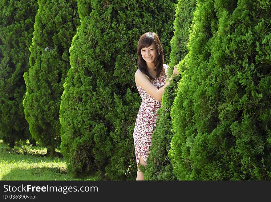 Young beautiful girl smiling outdoor near pine tree. Young beautiful girl smiling outdoor near pine tree