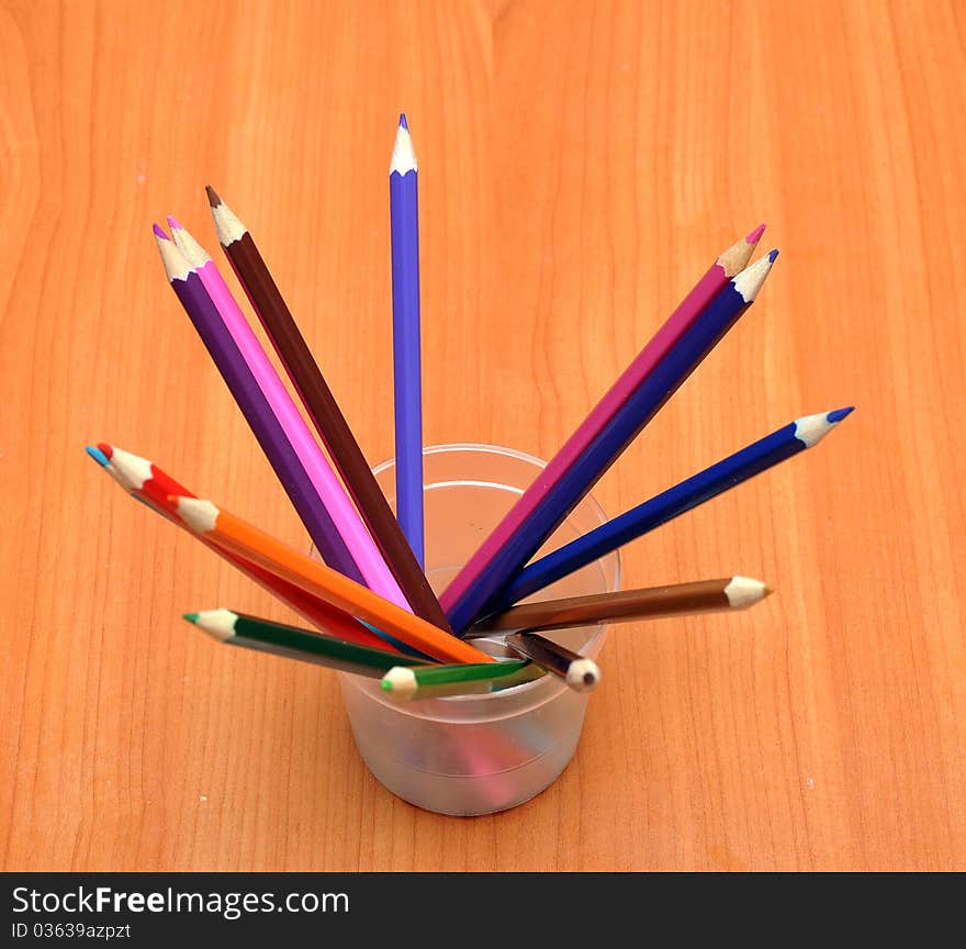 Pencils in glass on wood background. Pencils in glass on wood background