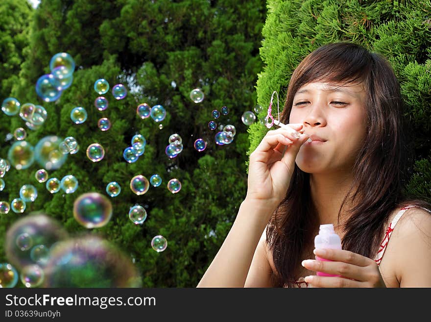 Young beautiful girl smiling outdoor play with bubble soap. Young beautiful girl smiling outdoor play with bubble soap