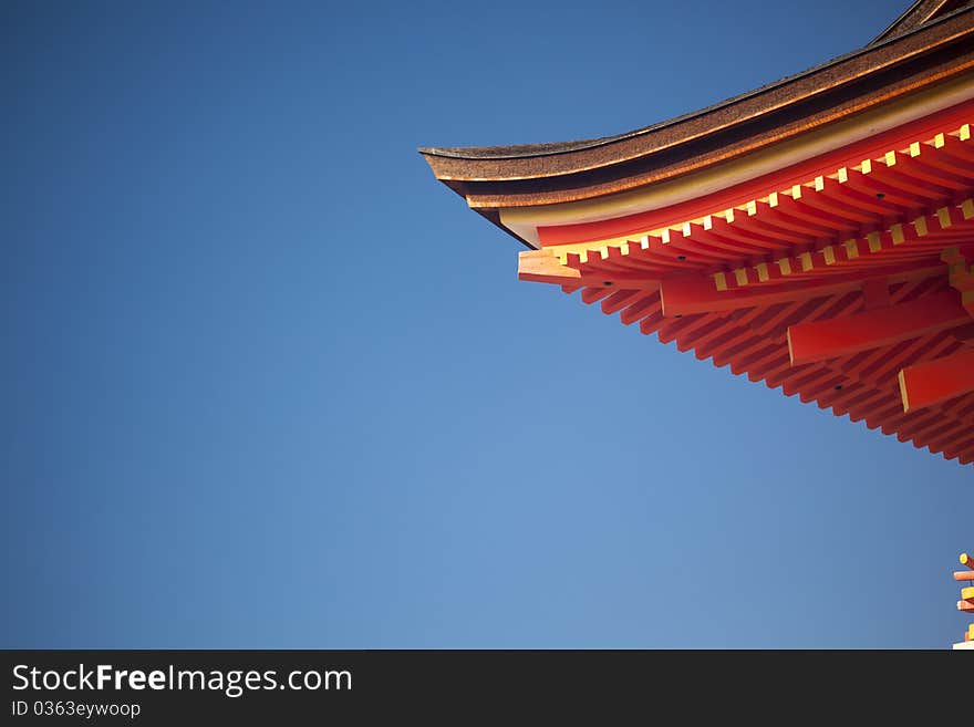 Asian roof detail over clear blue sky