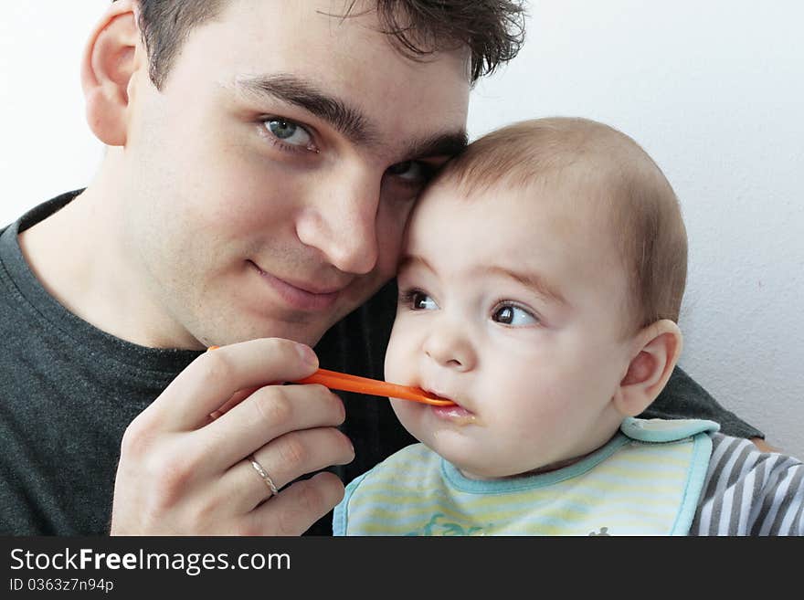 Father giving food to baby