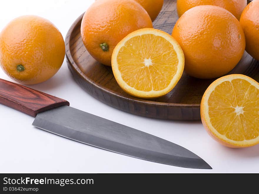 Oranges and knives on plate