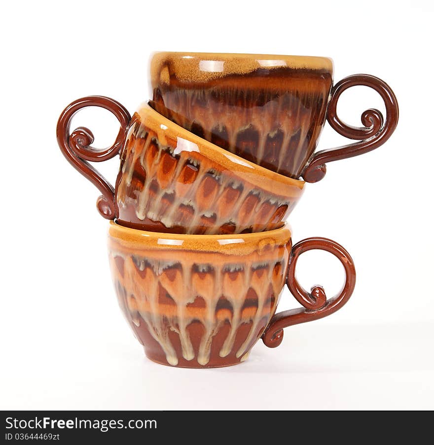 Large stack of ceramic tea cups closeup, isolated on a white background