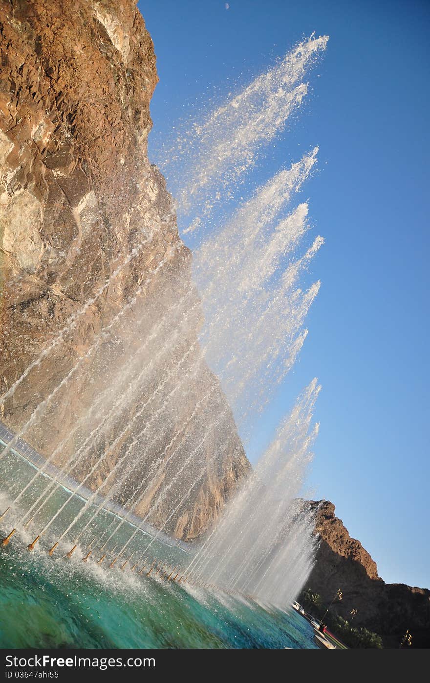 An angled shot from a series of fountains springing water forming a water wall. MUSCAT, OMAN. An angled shot from a series of fountains springing water forming a water wall. MUSCAT, OMAN