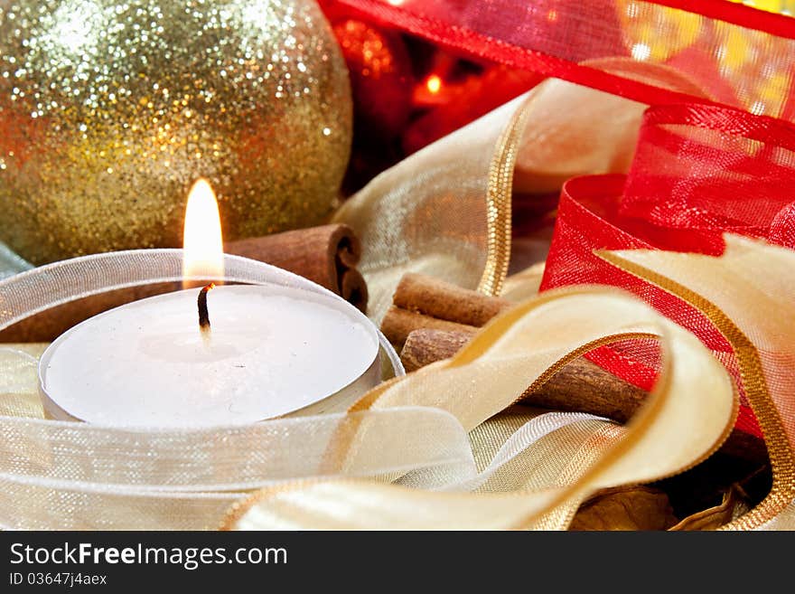 Candle on random background with ribbons, cinnamon and balls. Candle on random background with ribbons, cinnamon and balls