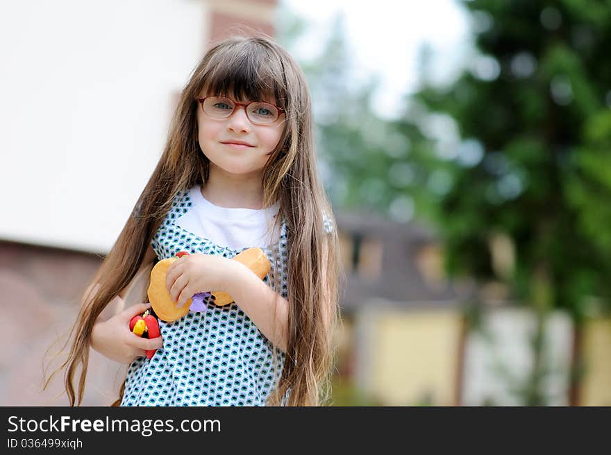 Adorable little girl with long dark hair plays with her toy food. Adorable little girl with long dark hair plays with her toy food