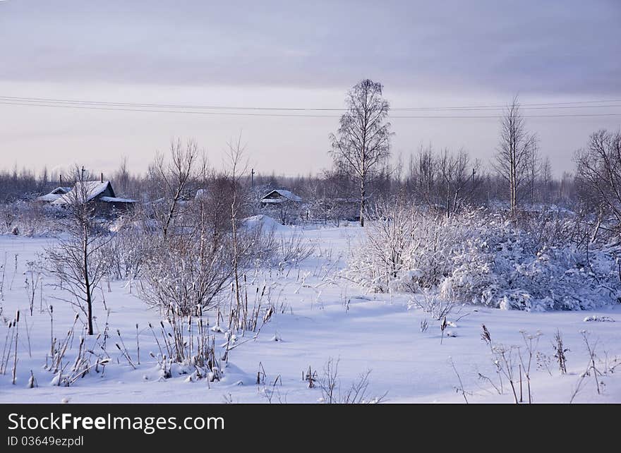 Winter rural landscape with snow and ice-covered grass