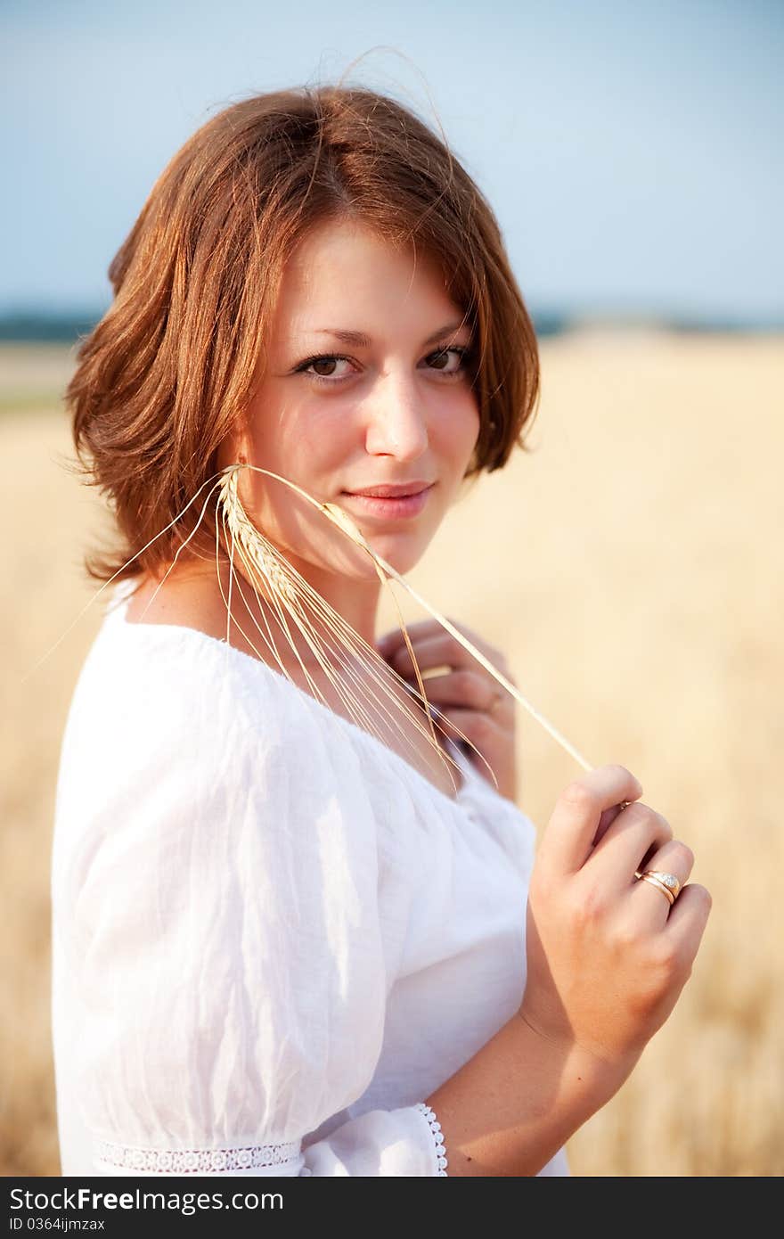 Beautiful young woman standing in wheat field. Beautiful young woman standing in wheat field