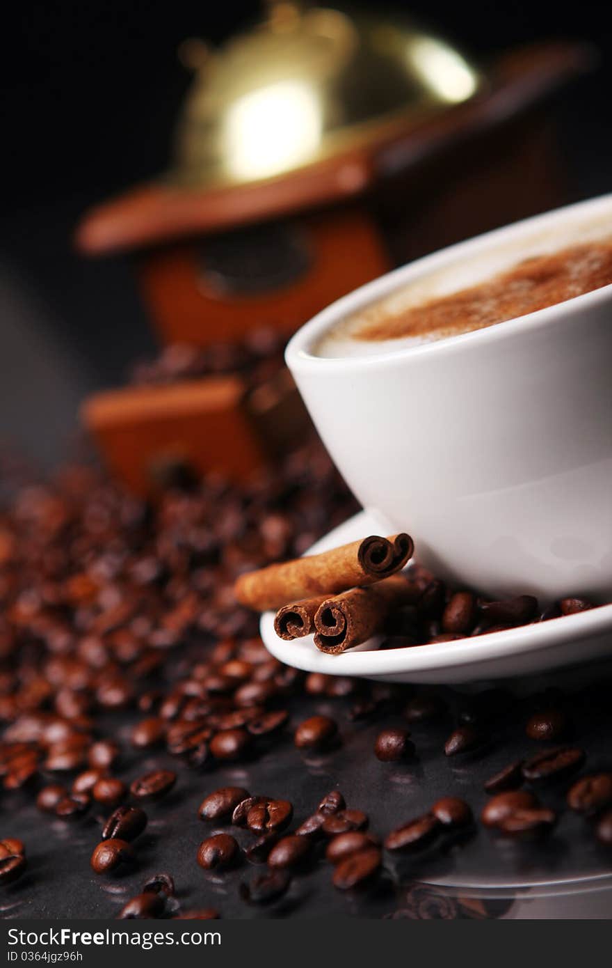 Coffee cup on the table with coffee beans around