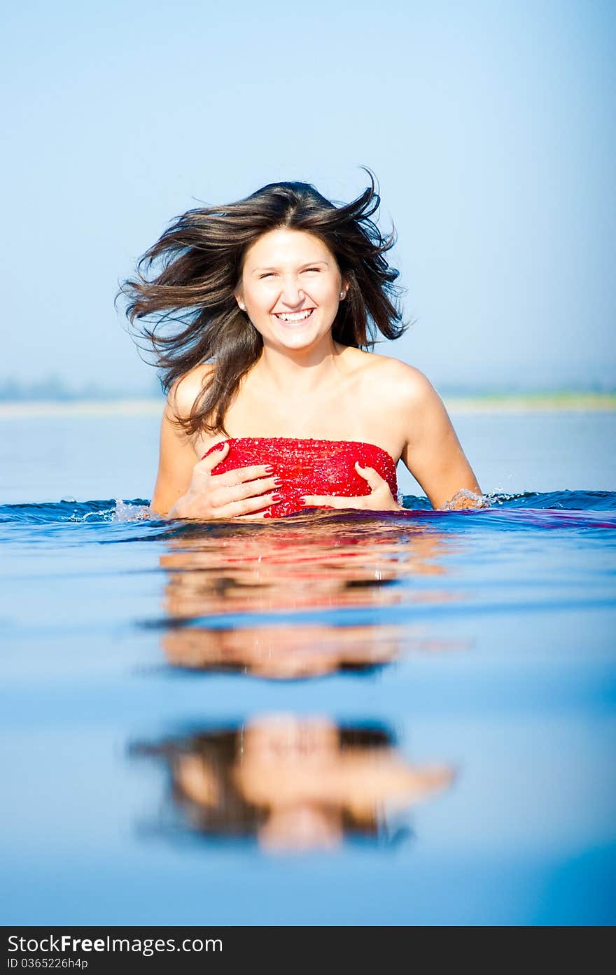 Woman in red dress on coast