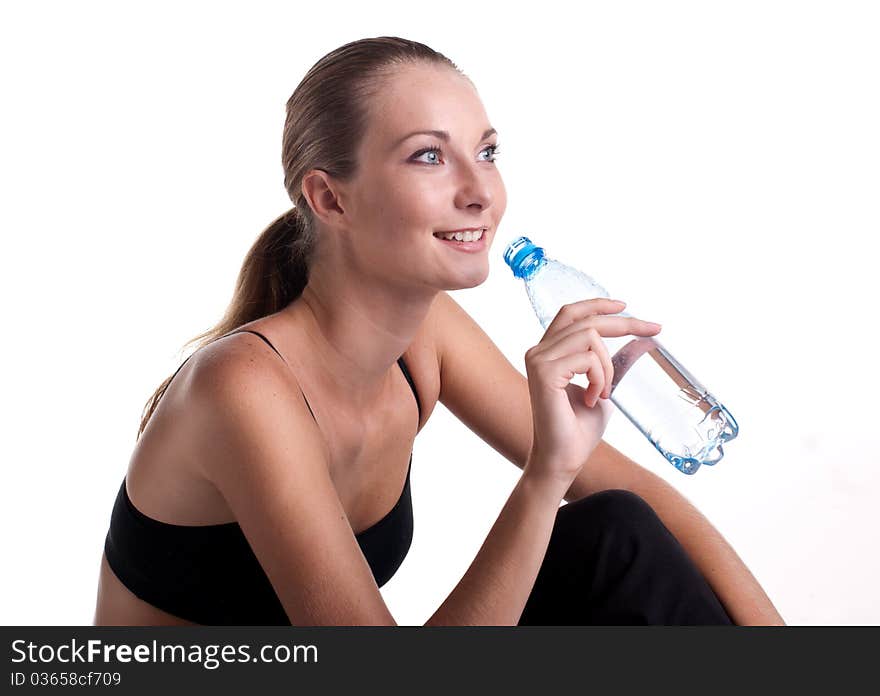 Woman in fitness pose holding water bottle, studio shot