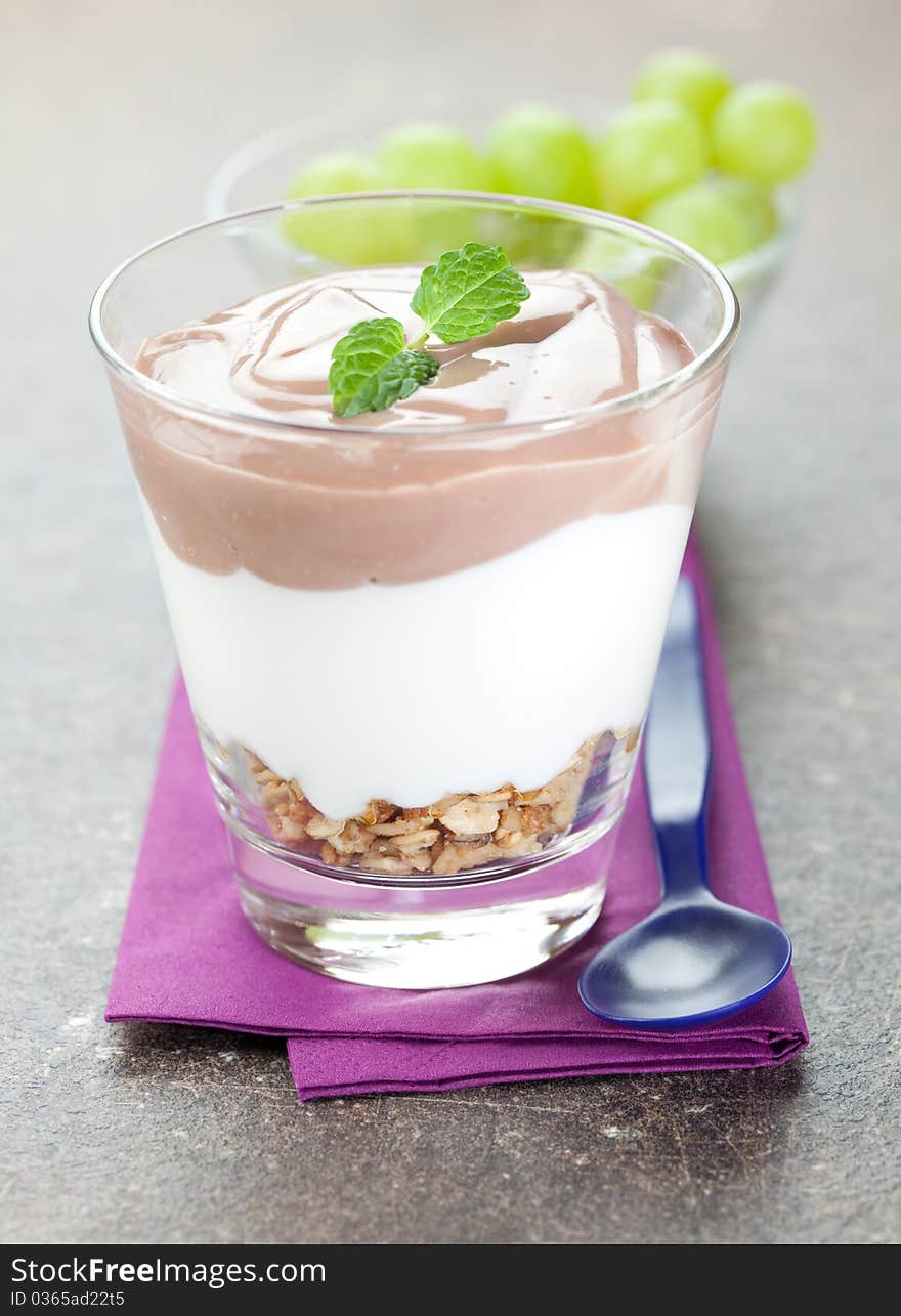 Fresh dessert (cereals, pudding and cream) served in a glass on napkin. Fresh dessert (cereals, pudding and cream) served in a glass on napkin