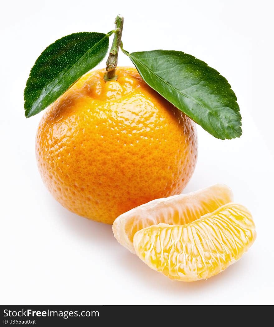 Image of a ripe tangerine with leaves on white