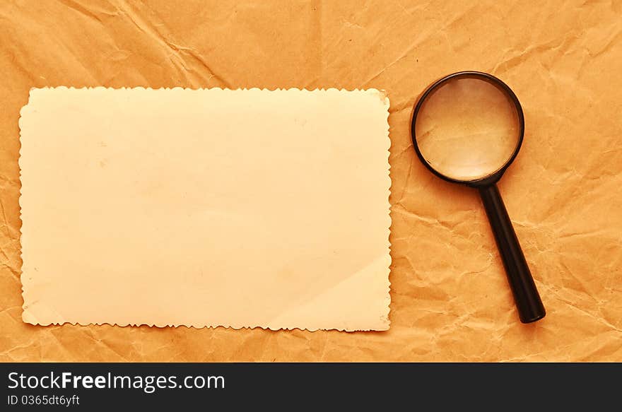 Vintage photo with a decorative border and magnifying glass on old paper