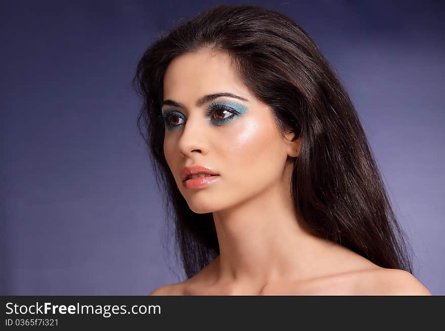 Brunette girl posing in studio on blue background. Brunette girl posing in studio on blue background