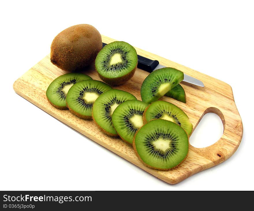 Sliced & whole kiwi fruits on a wooden chopping board. Sliced & whole kiwi fruits on a wooden chopping board