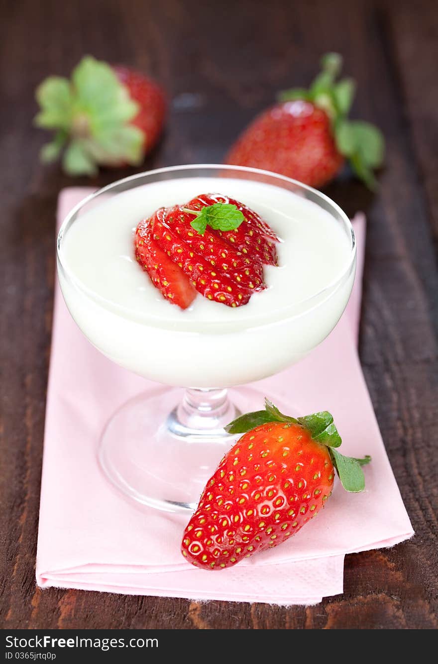 Fresh cream dessert with strawberry in a glass on napkin with fresh strawberries. Fresh cream dessert with strawberry in a glass on napkin with fresh strawberries