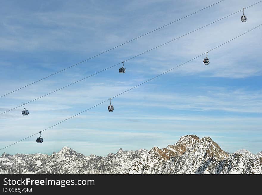 Winter Holiday Gondola Ski Lift Above Alps Mountains