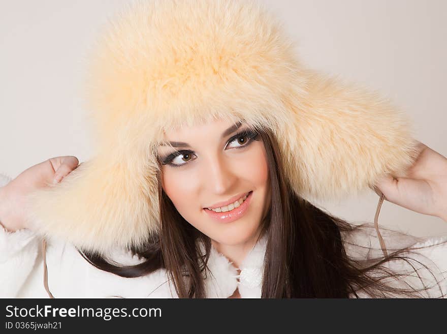 Happy brunette girl with furry hat, close up shot