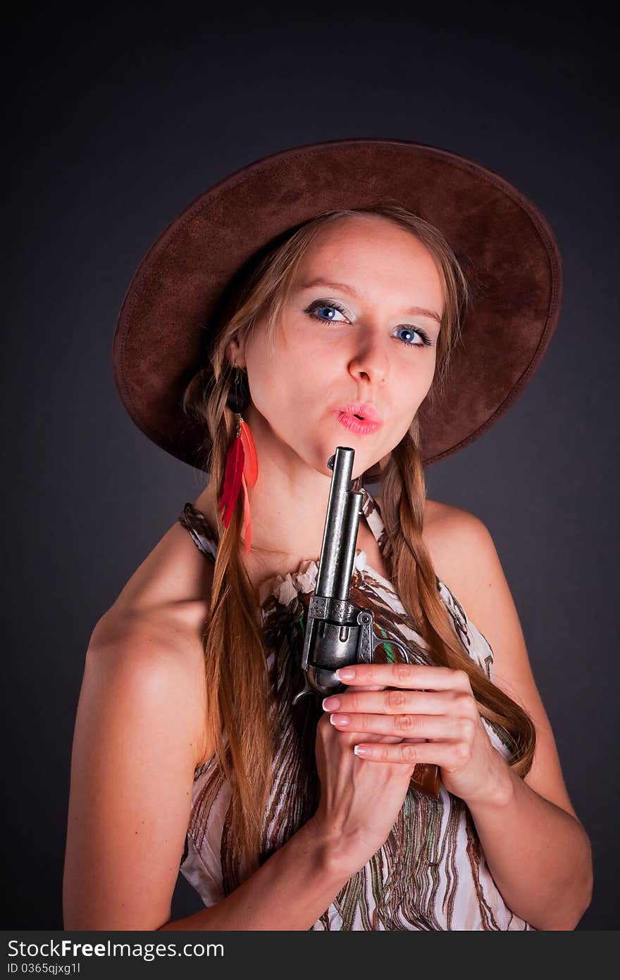 The American Indian girl in a cowboy's hat holds a pistol