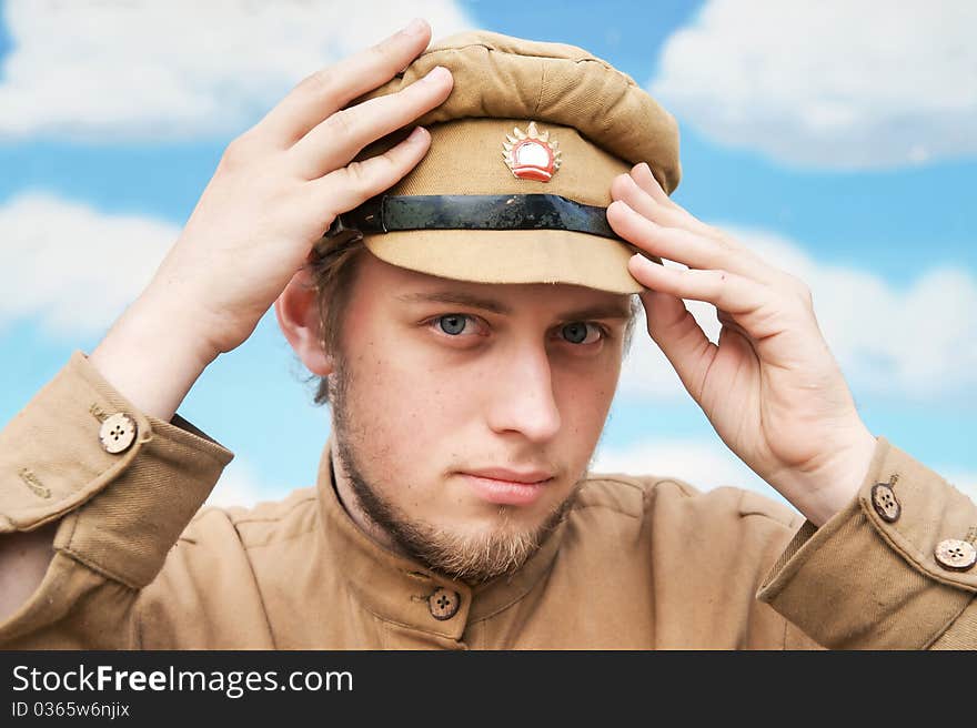 Portrait of soldier in uniform of World War 1 on the background of blue sky. Costume accord the times of World War I. Photo made at cinema city Cinevilla in Latvia. Cockade on the hat do not contain trade mark. Portrait of soldier in uniform of World War 1 on the background of blue sky. Costume accord the times of World War I. Photo made at cinema city Cinevilla in Latvia. Cockade on the hat do not contain trade mark.