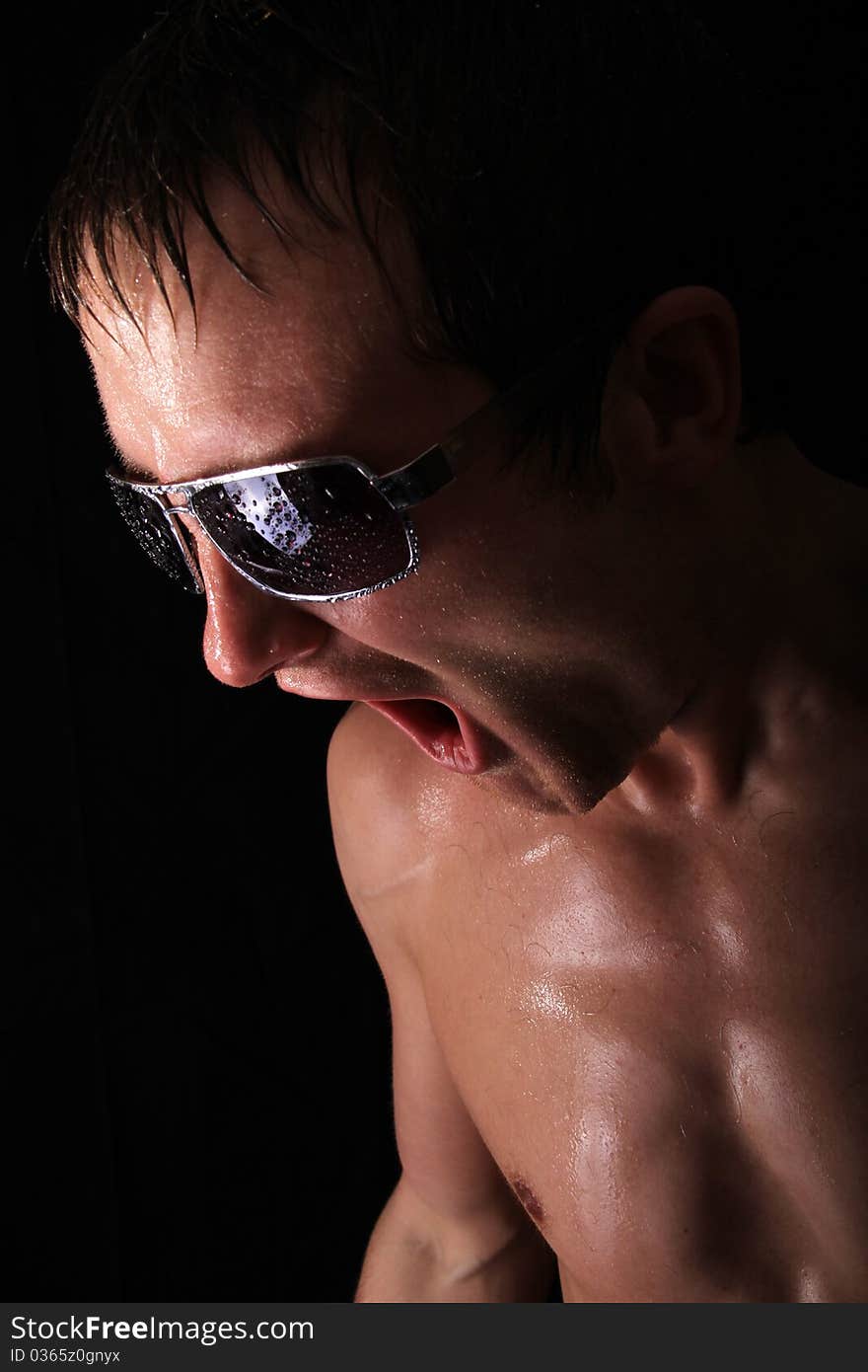 Male model screaming with intense light shinging on him