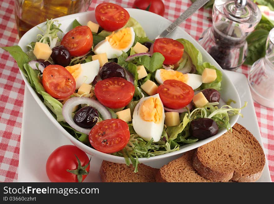 A simple, fresh salad of lettuce, tomatoes, egg, black olives, onions and cheese. Served with wholemeal bread.