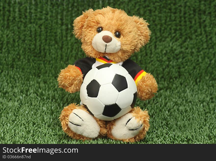 Teddy bear with football shirt on lawn background. Teddy bear with football shirt on lawn background