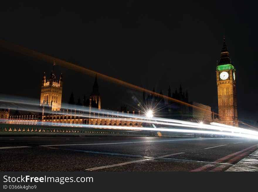 Lights of buses and cars passing the well lit buildings of the houses of parliament and big ben. Lights of buses and cars passing the well lit buildings of the houses of parliament and big ben