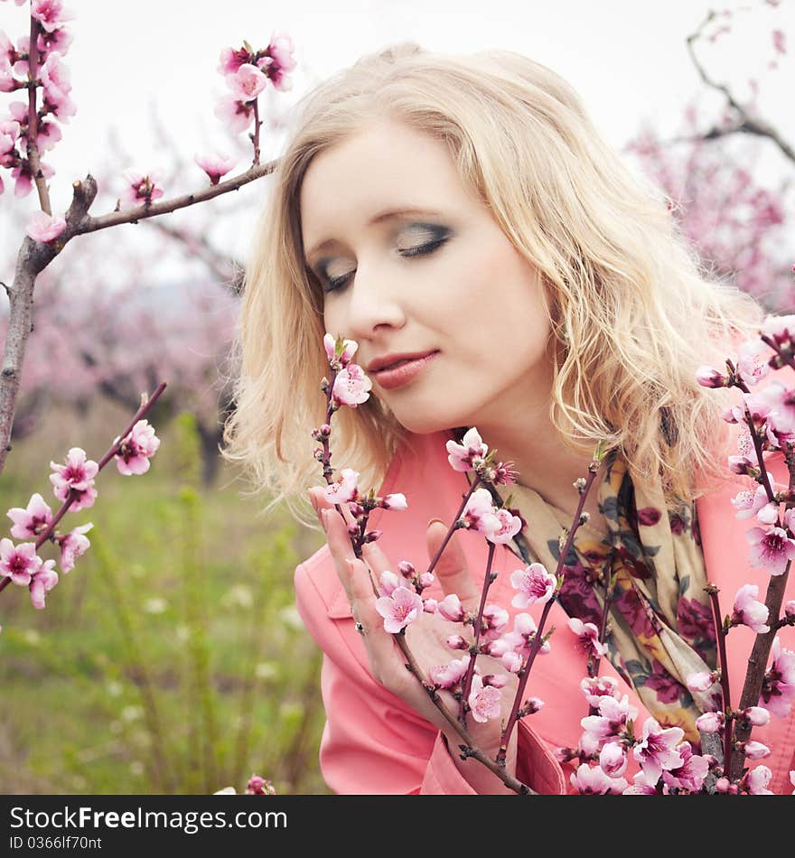 Beautiful blonde girl in spring peach garden. Beautiful blonde girl in spring peach garden