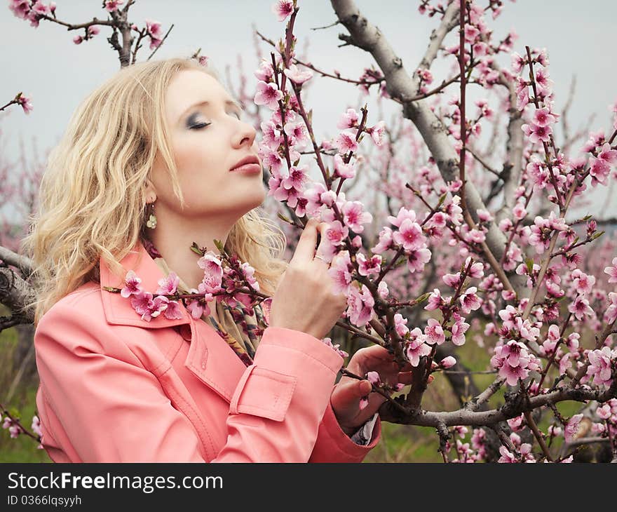 Beautiful blonde girl in spring peach garden. Beautiful blonde girl in spring peach garden