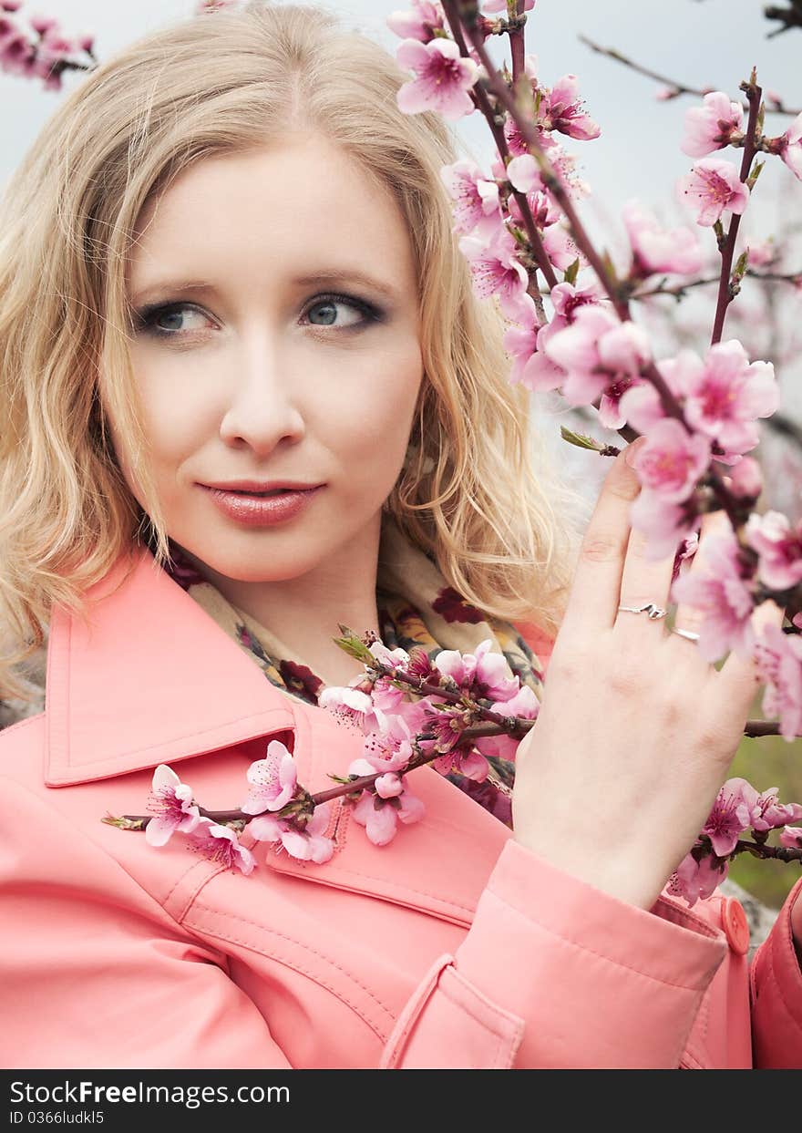 Beautiful blonde girl in spring peach garden. Beautiful blonde girl in spring peach garden