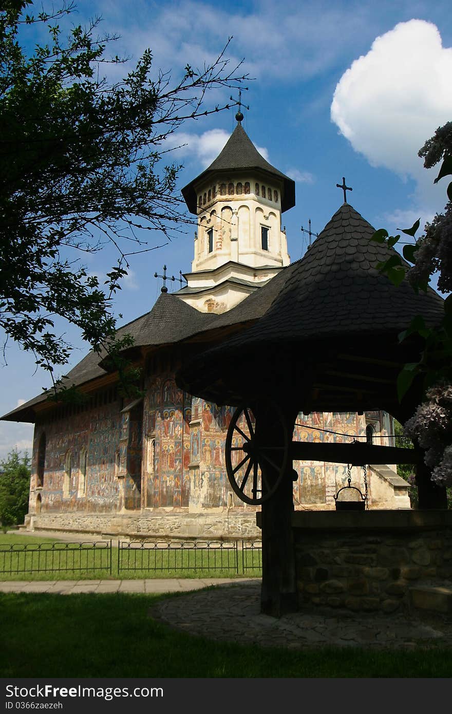 Moldovita monastery's interior garden with well and blue sky