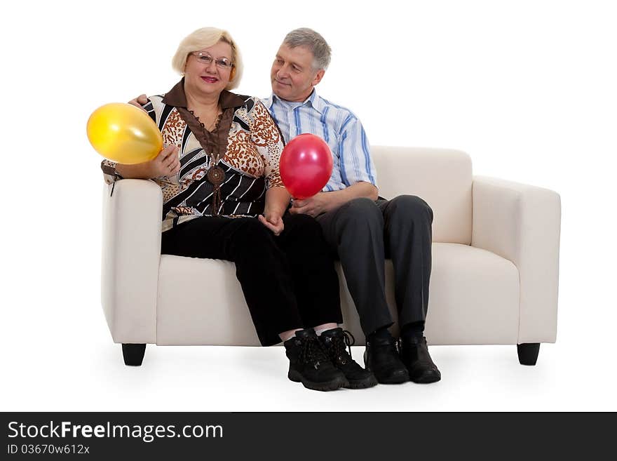 Mature couple sitting on a sofa on a white background