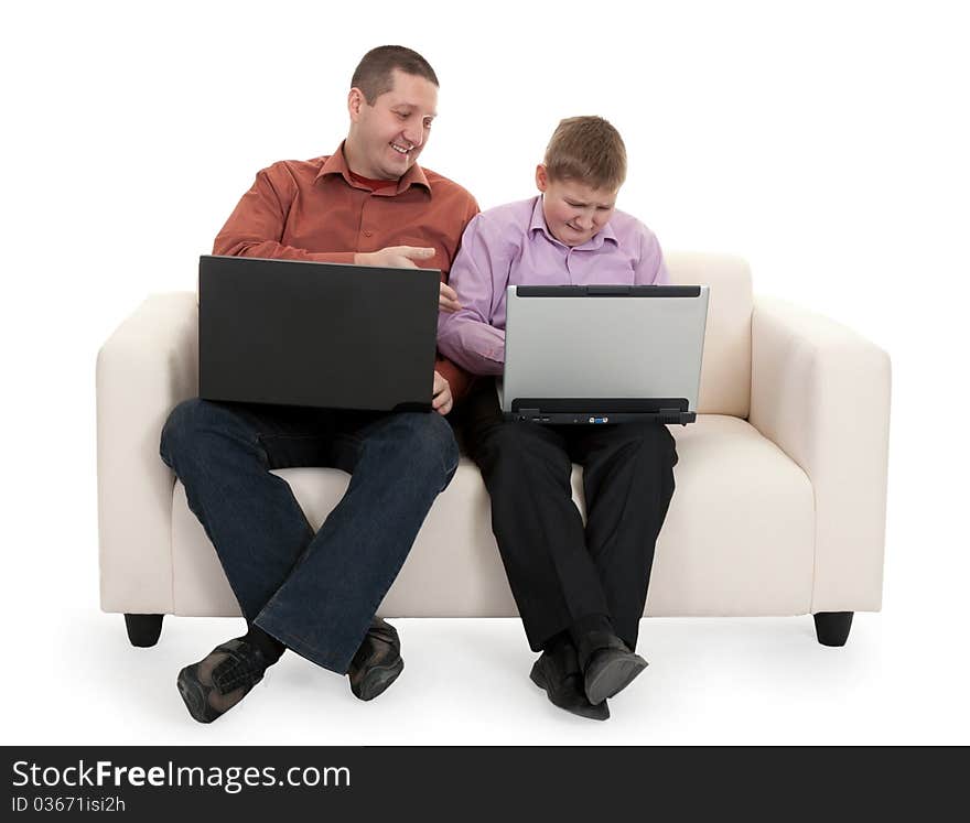 Father and son sitting on the couch with laptops