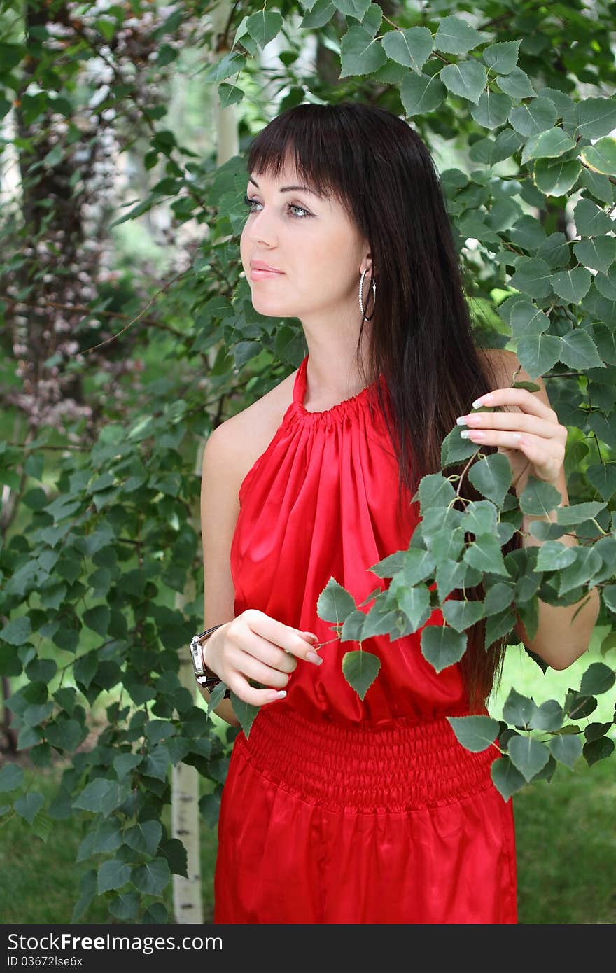 Outdoor portrait of the brunette girl in red