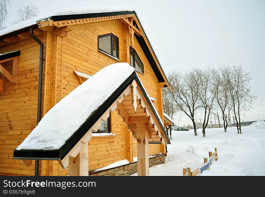 Traditional suburban house, comfortable and warm in winter, residential structure, building exterior, non-urban scene, residential districtstained wood and double windows secure, surrounded by deep snow, pleasant yellow and brown colors. Traditional suburban house, comfortable and warm in winter, residential structure, building exterior, non-urban scene, residential districtstained wood and double windows secure, surrounded by deep snow, pleasant yellow and brown colors