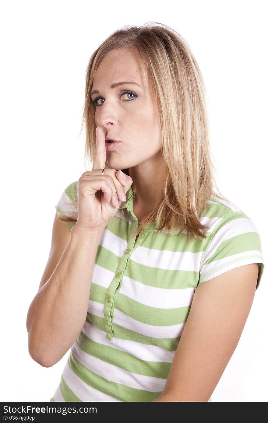 A woman in a green and white striped shirt making a face expression to be quiet. A woman in a green and white striped shirt making a face expression to be quiet.