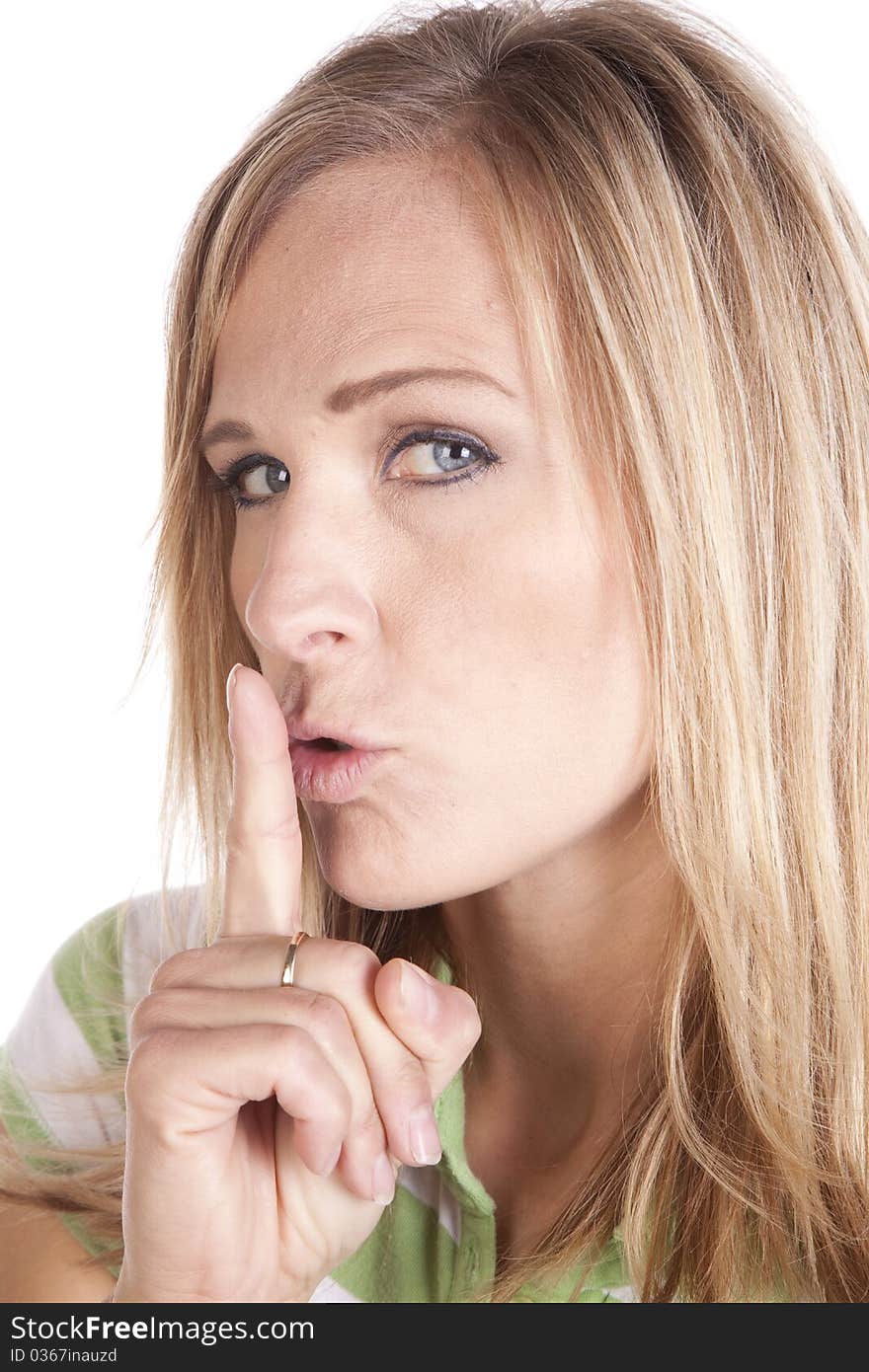 A woman in a green and white striped shirt making a face expression to be quiet. A woman in a green and white striped shirt making a face expression to be quiet.