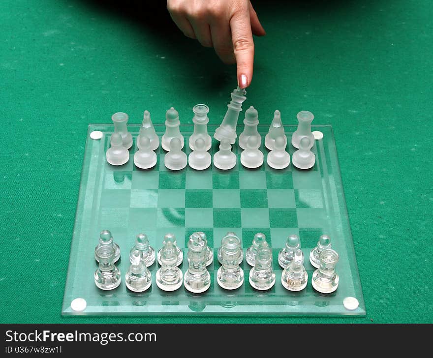 A female hand throwing down the king on a chess match. A female hand throwing down the king on a chess match.