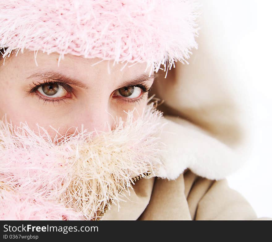 Portrait of pretty woman with face covered by scarf and hat outside in the snow. Portrait of pretty woman with face covered by scarf and hat outside in the snow