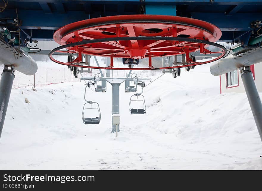 Ski lift equipment that is transporting skiers up to the hills.