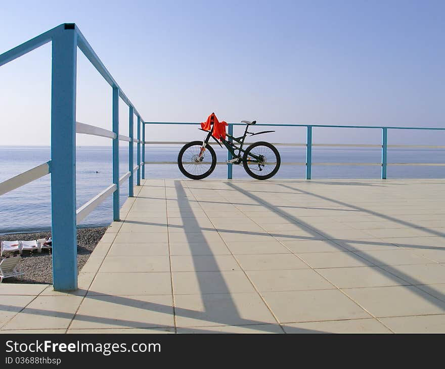 Alone Bicycle At The Seafront Fence In Sunny Day