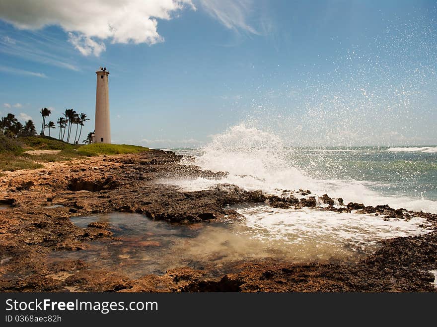 Wave crashing into rocky coast, Barber's Point Lighthouse in the distance. Oahu Hawaii, 2009. Wave crashing into rocky coast, Barber's Point Lighthouse in the distance. Oahu Hawaii, 2009.