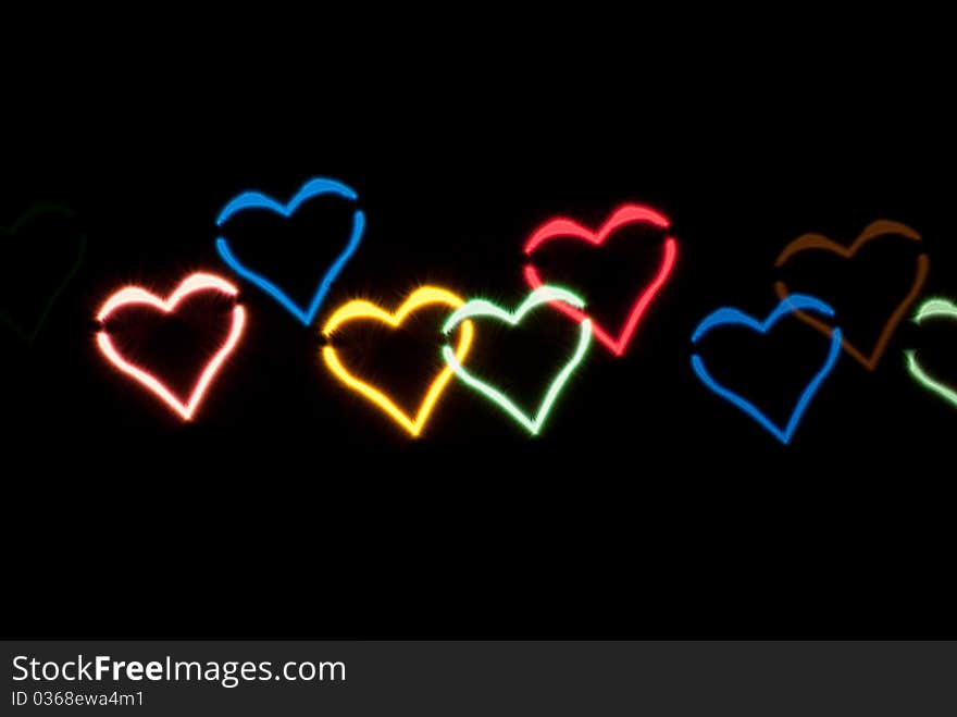 Light effect in the form of hearts on black background. Light effect in the form of hearts on black background