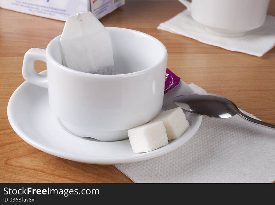 Cup for tea, sugar and spoon on table