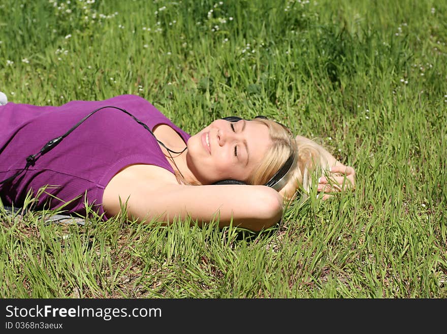 Beautiful young girl with headphones, listen to music on meadow. Beautiful young girl with headphones, listen to music on meadow