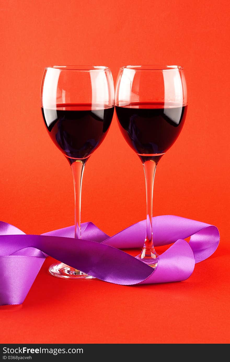 Two Glasses Of Wine On A Red Background.