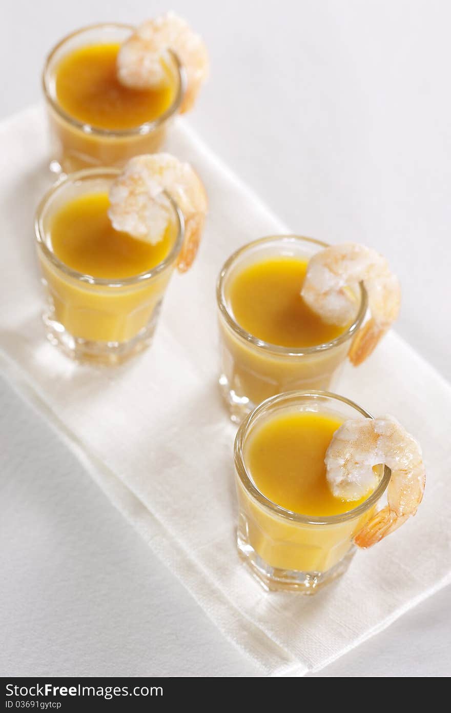 Party snack. Pumpkin soup with orange juice in the glasses and grilled tiger prawns. Party snack. Pumpkin soup with orange juice in the glasses and grilled tiger prawns