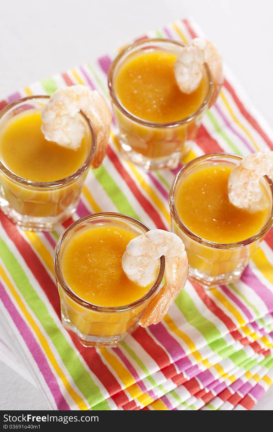 Party snack. Pumpkin soup with orange juice in the glasses and grilled tiger prawns. Party snack. Pumpkin soup with orange juice in the glasses and grilled tiger prawns